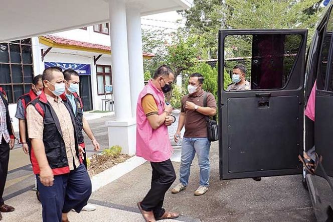 
					Tujuh tahanan korupsi Kejari Rohul berjalan menuju mobil tahanan untuk dipindahkan ke Rutan Sialang Bungkuk, Pekanbaru, Jumat (21/1/2022). (ENGKI PRIMA PUTRA/RIAUPOS.CO)