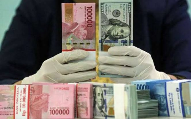 
					Karyawati salah satu bank memperlihatkan uang rupiah dan dolar di Jakarta, Kamis (29/4/2021). Bisnis