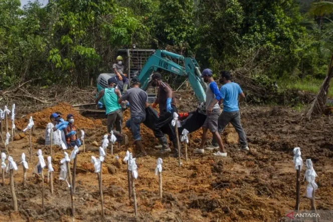 
					Arsip Foto. Sejumlah petugas pemakaman mengangkat kantong berisi jenazah korban tanah longsor untuk dimakamkan di Kecamatan Serasan, Kabupaten Natuna, Kepulauan Riau, Sabtu (11/3/2023). (ANTARA FOTO/Teguh Prihatna/nym)