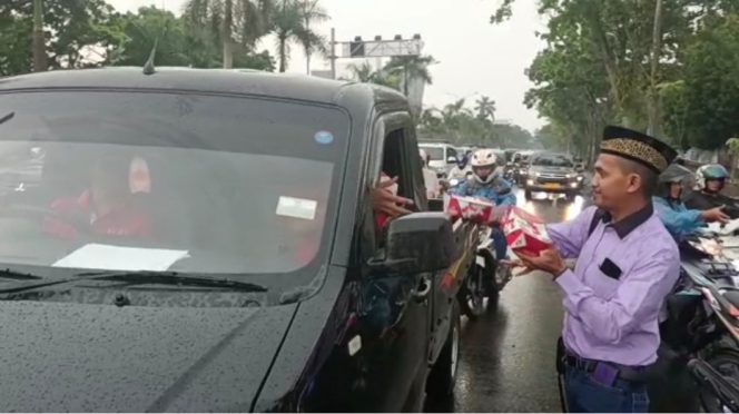 
					Ketua DPP AMI, Ismail Sarlata membagikan takjil kepada pengendara mobil di jalan Jendral Sudirman Pekanbaru.