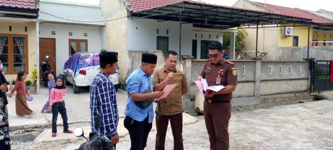 
					Kasi Pidsus Kejari Kampar, Marthalius pimpin pemasangan plang yang berisi amar putusan untuk dirampas Negara dan pemasangan line kejaksaan.