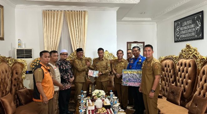 
					Bupati Kampar, Ahmad Yuzar menyerahkan batuan bencana (Foto: Istimewa)
